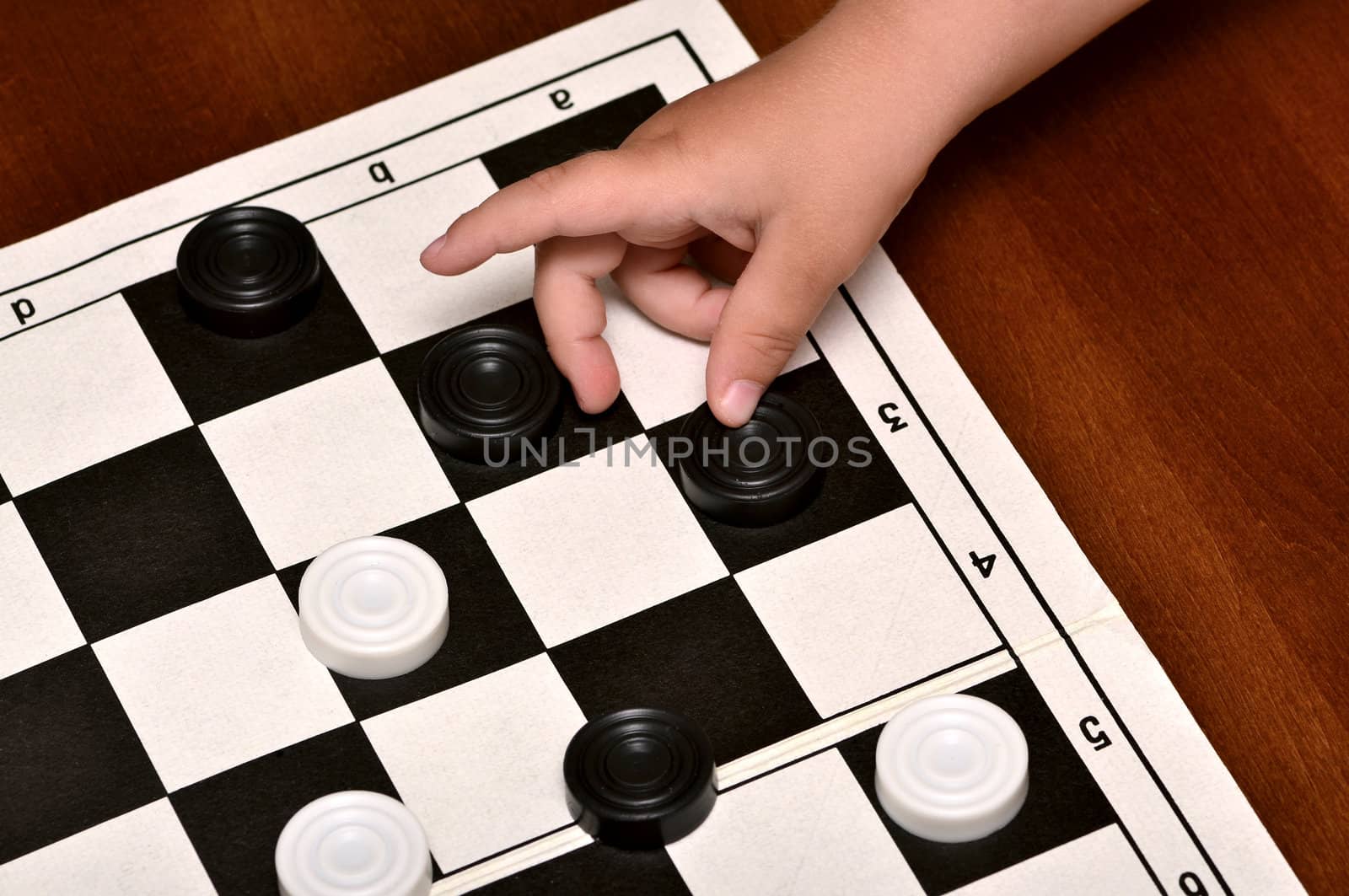 little boy plays checkers