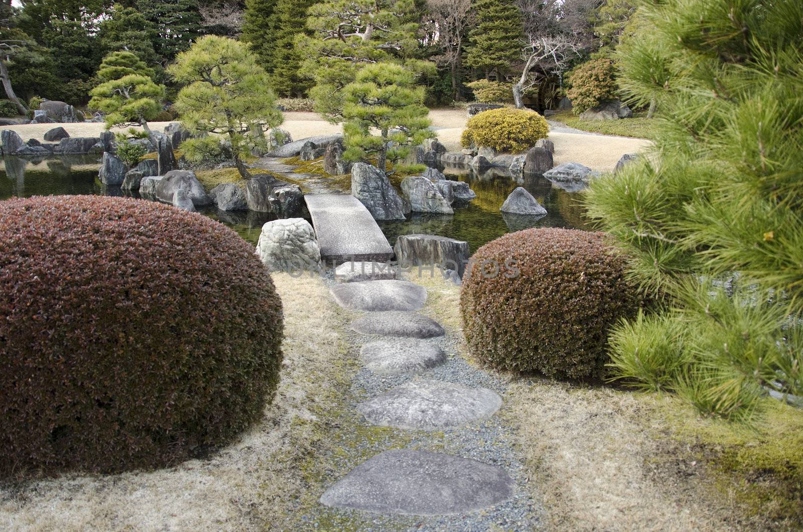 Japanese garden with lake, stepping stones and bridge