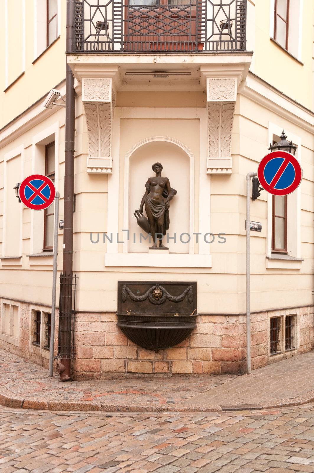 Old street with beautiful sculpture and road signs of old Riga capital of Latvia