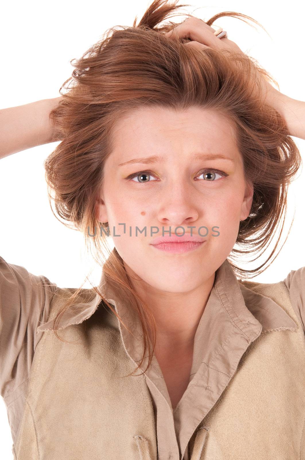 Confused Beautiful young woman with hands in her hair over white.