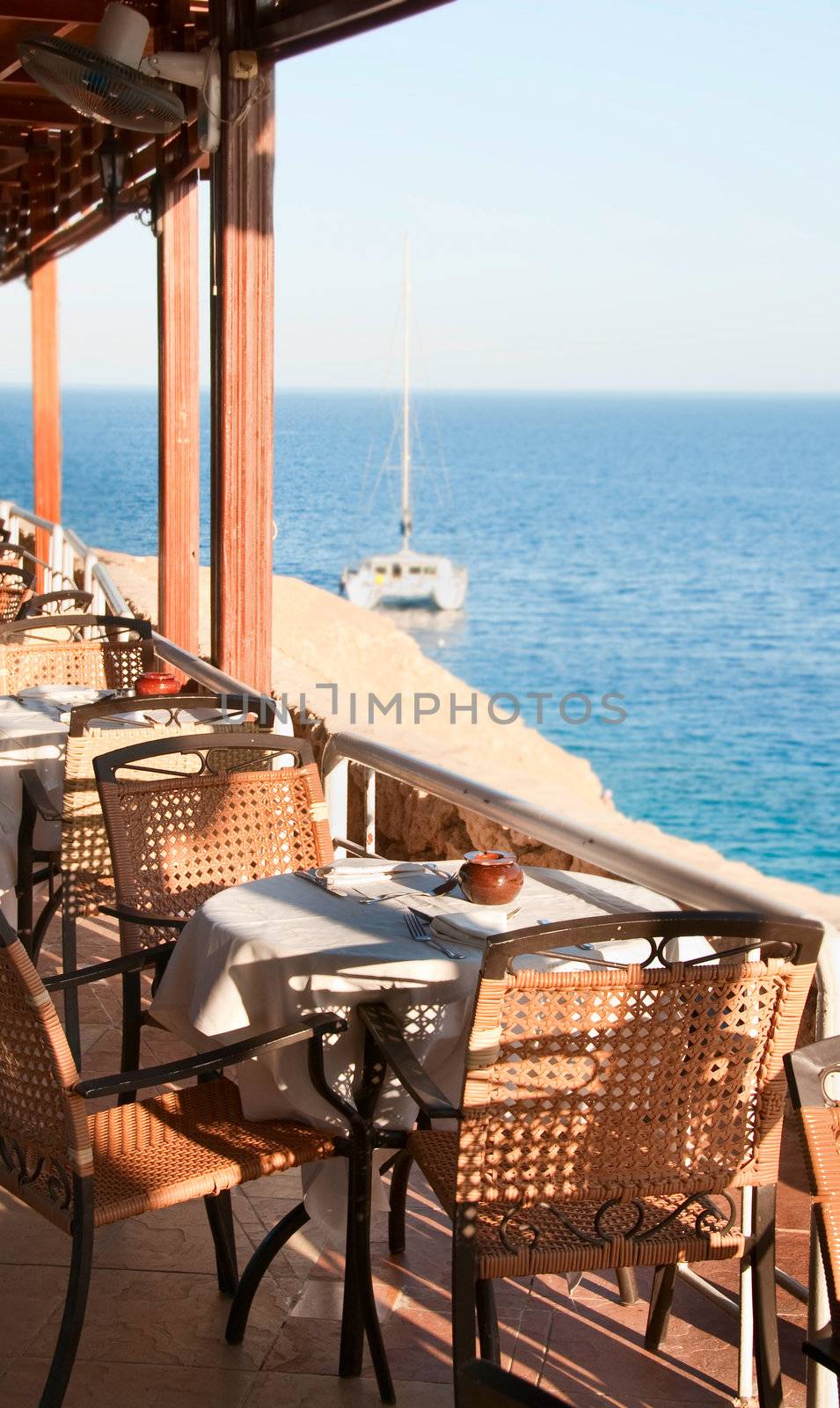 Restaurant near the Red sea with yacht on background