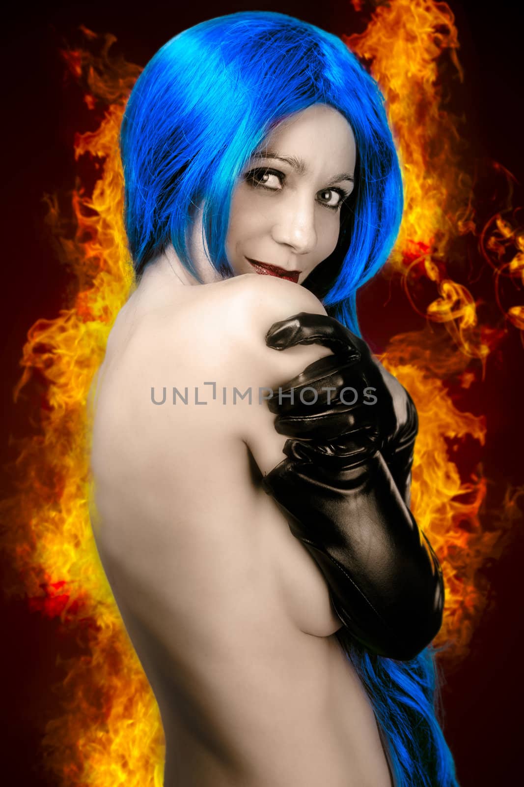 vogue style portrait of beautiful delicate woman with blue hair over fire flames