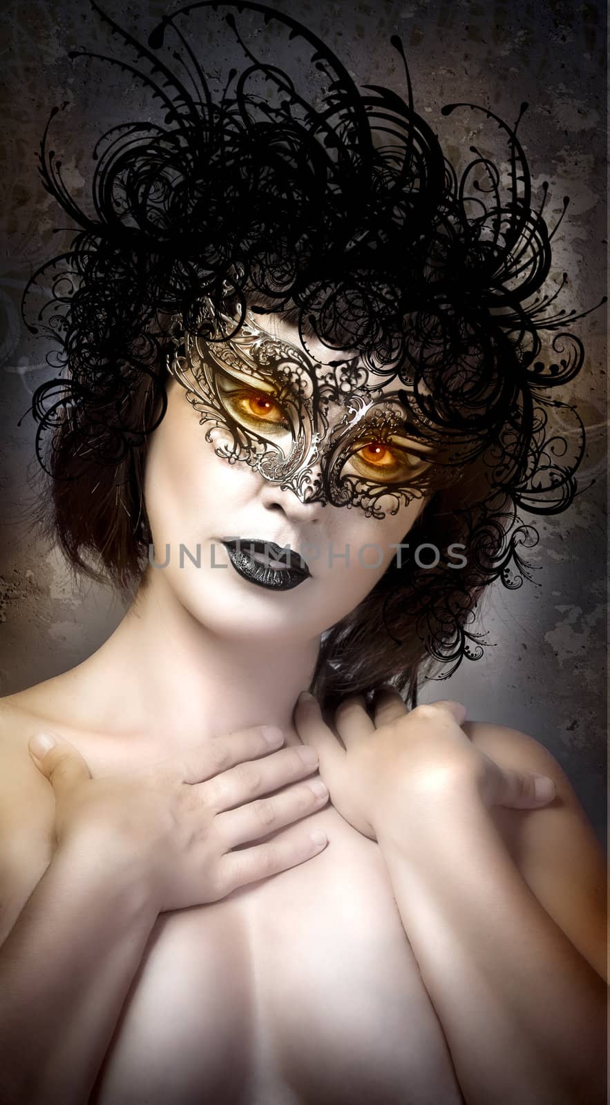 Young actress with venetian mask over fantasy background