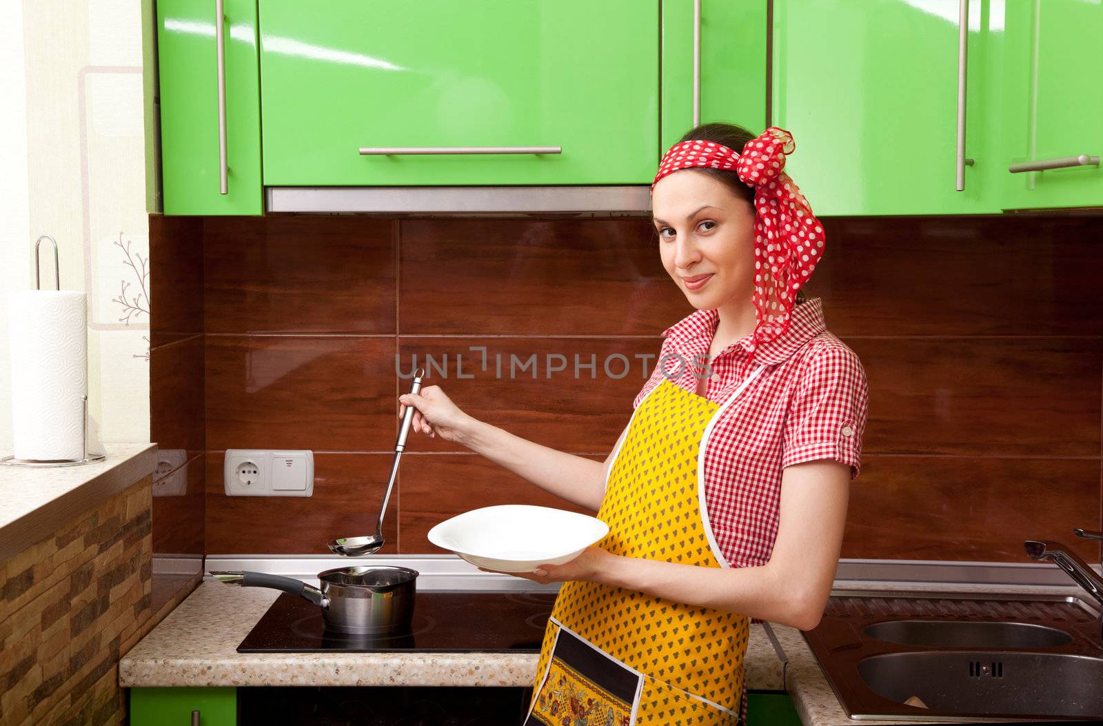 Beautiful happy smiling cooking woman in kitchen interior