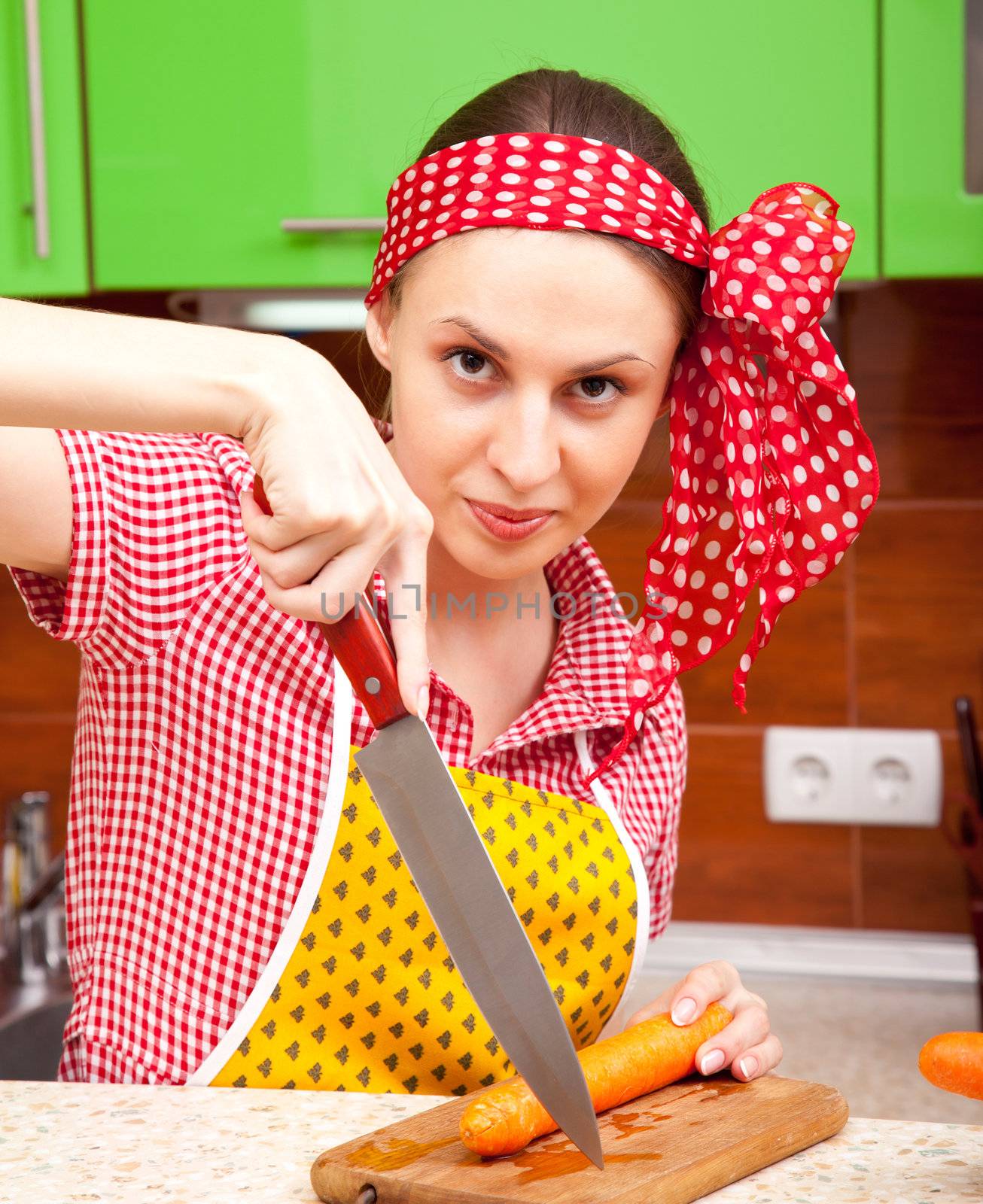 Woman in the kitchen with knife and vegetables by iryna_rasko