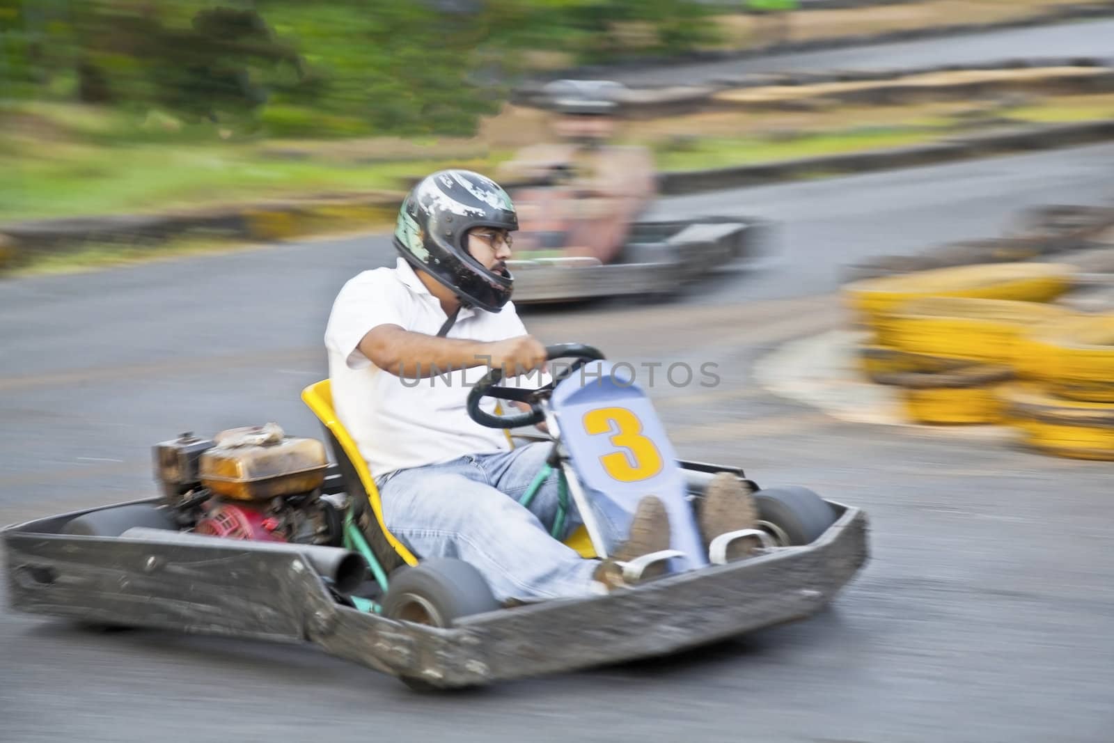 Horizontal landscape of young male driver taking a left hand hairpin bend extra fast. Generic shot location Goa India