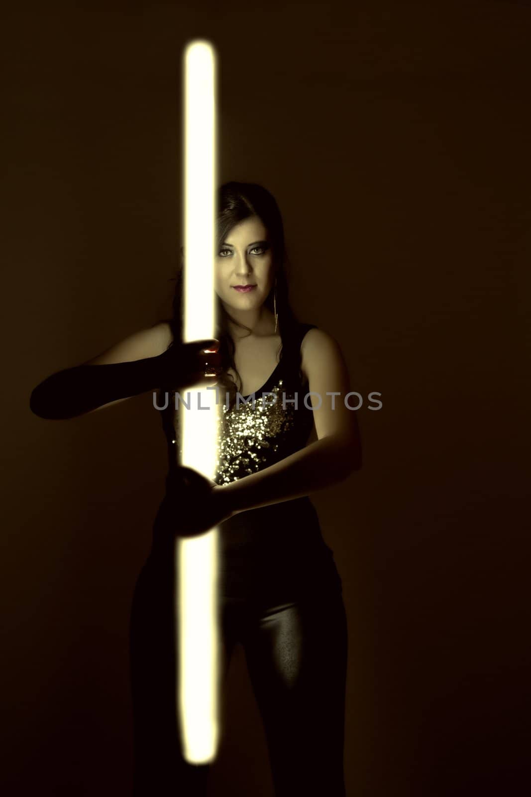 beautiful girl in dark leather clothes holding a light tube by membio