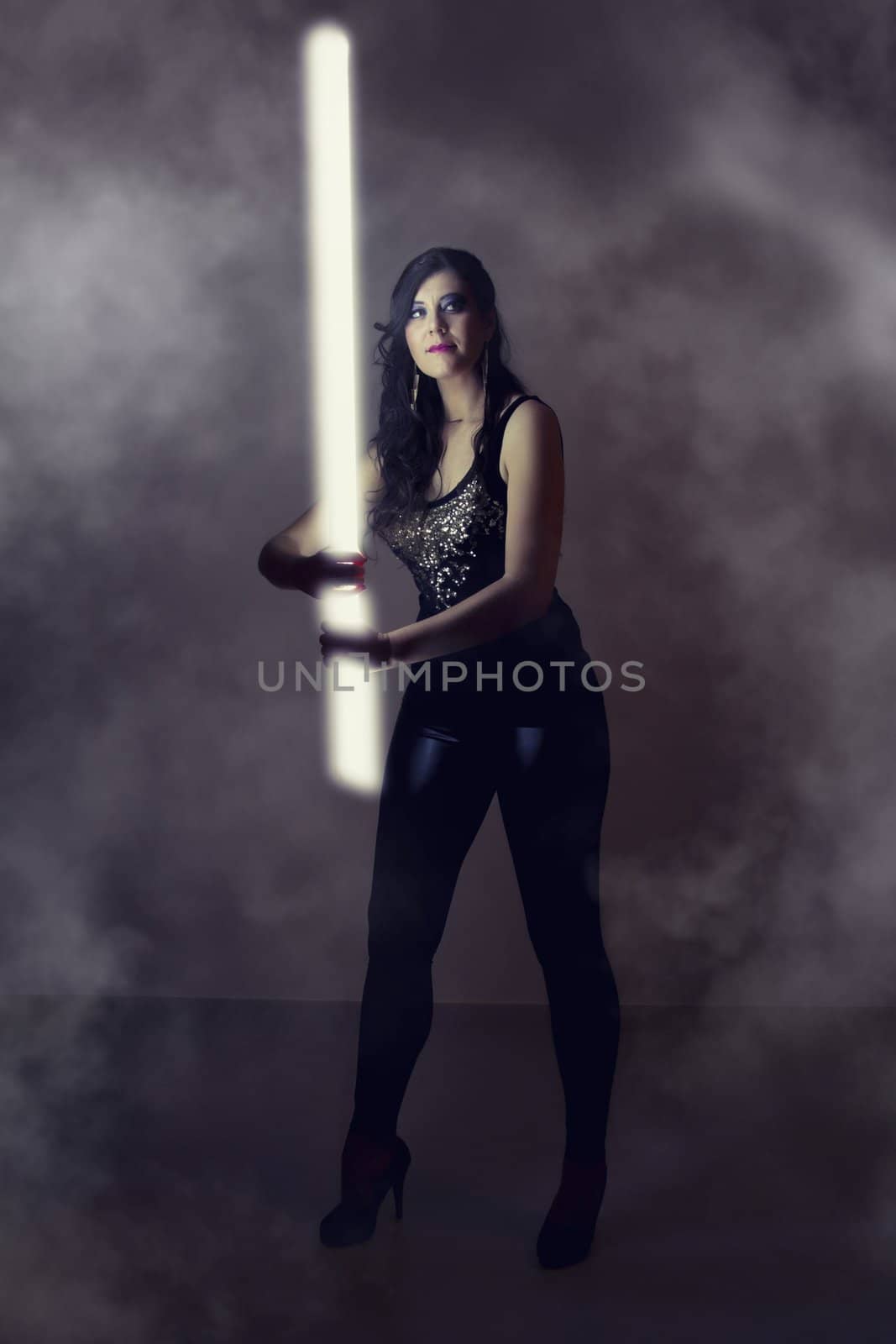 beautiful girl in dark leather clothes holding a light tube by membio