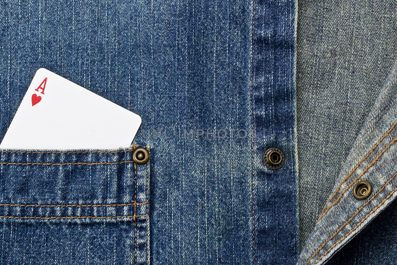 Close-up photograph of a playing card in a denim pocket.