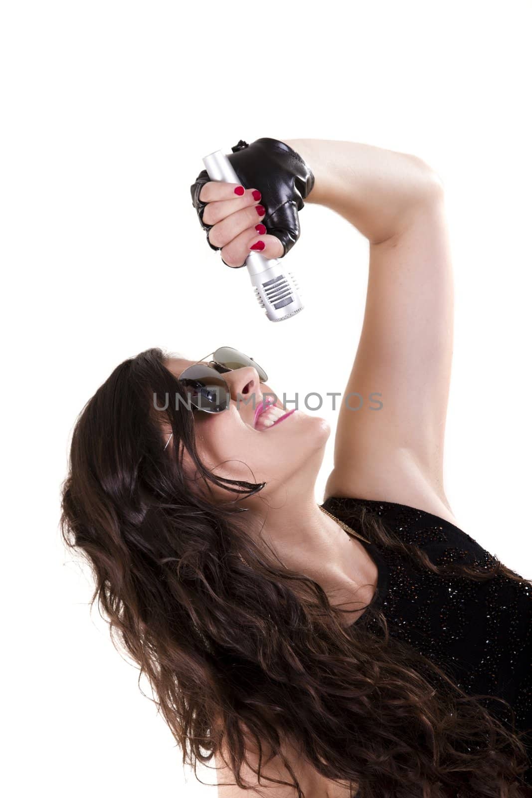 View of a beautiful girl in dark leather clothes against a white background holding a microphone.