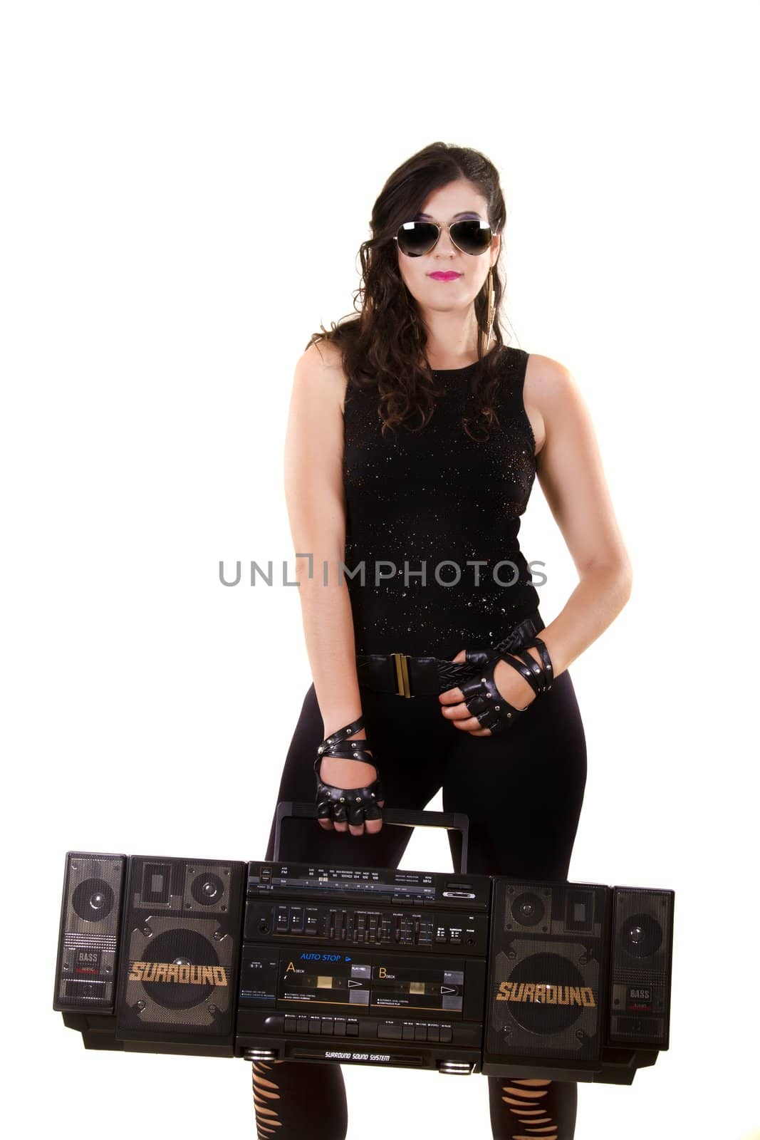 View of a beautiful girl in dark leather clothes against a white background holding a large retro radio.