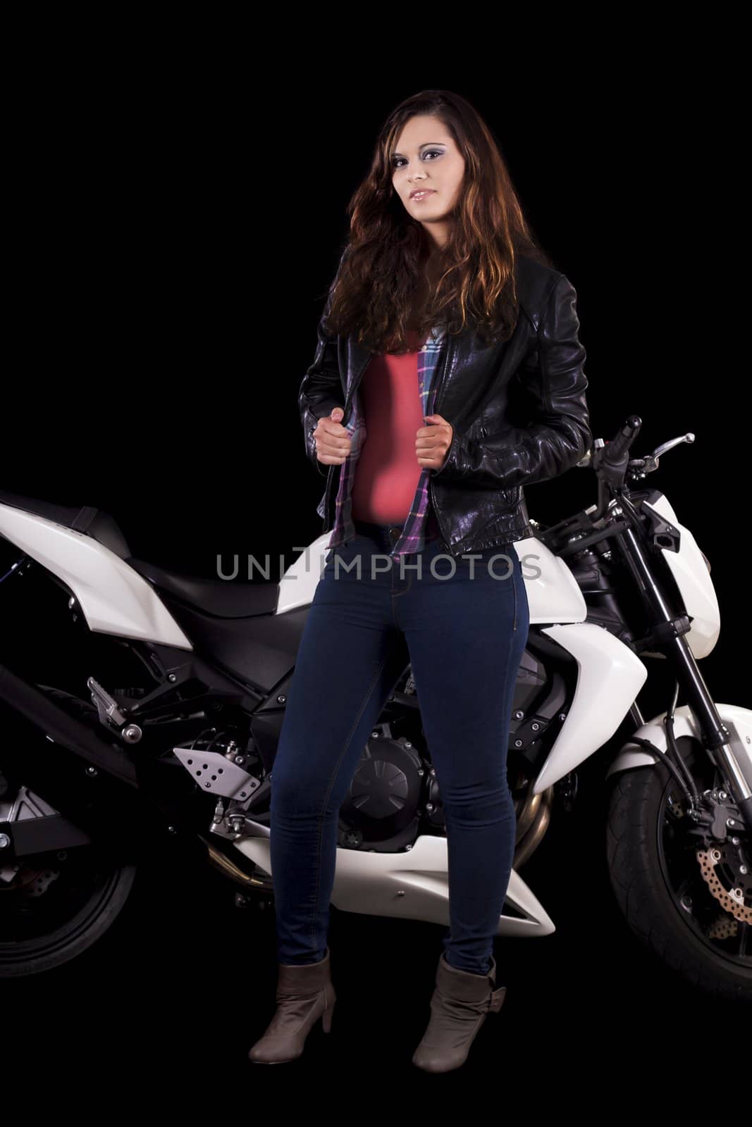 View of a beautiful young girl next to a white motorbike in a studio environment. 