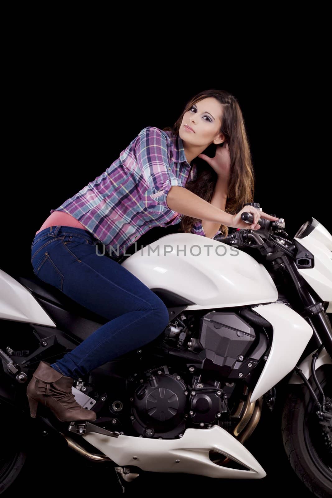 View of a beautiful young girl next to a white motorbike in a studio environment. 