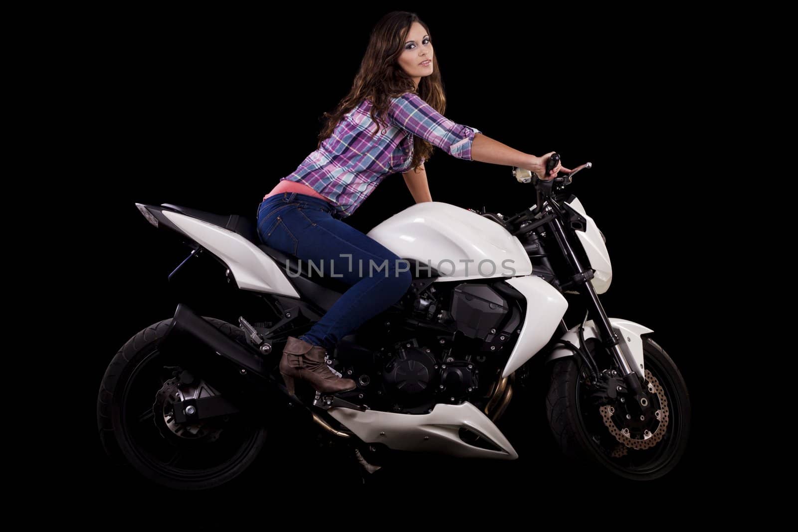 View of a beautiful young girl next to a white motorbike in a studio environment. 