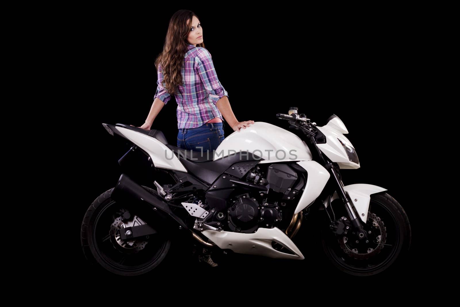 View of a beautiful young girl next to a white motorbike in a studio environment. 