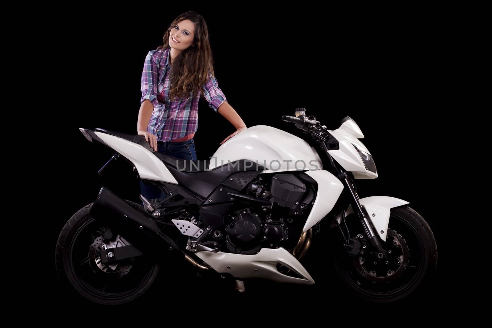 View of a beautiful young girl next to a white motorbike in a studio environment. 