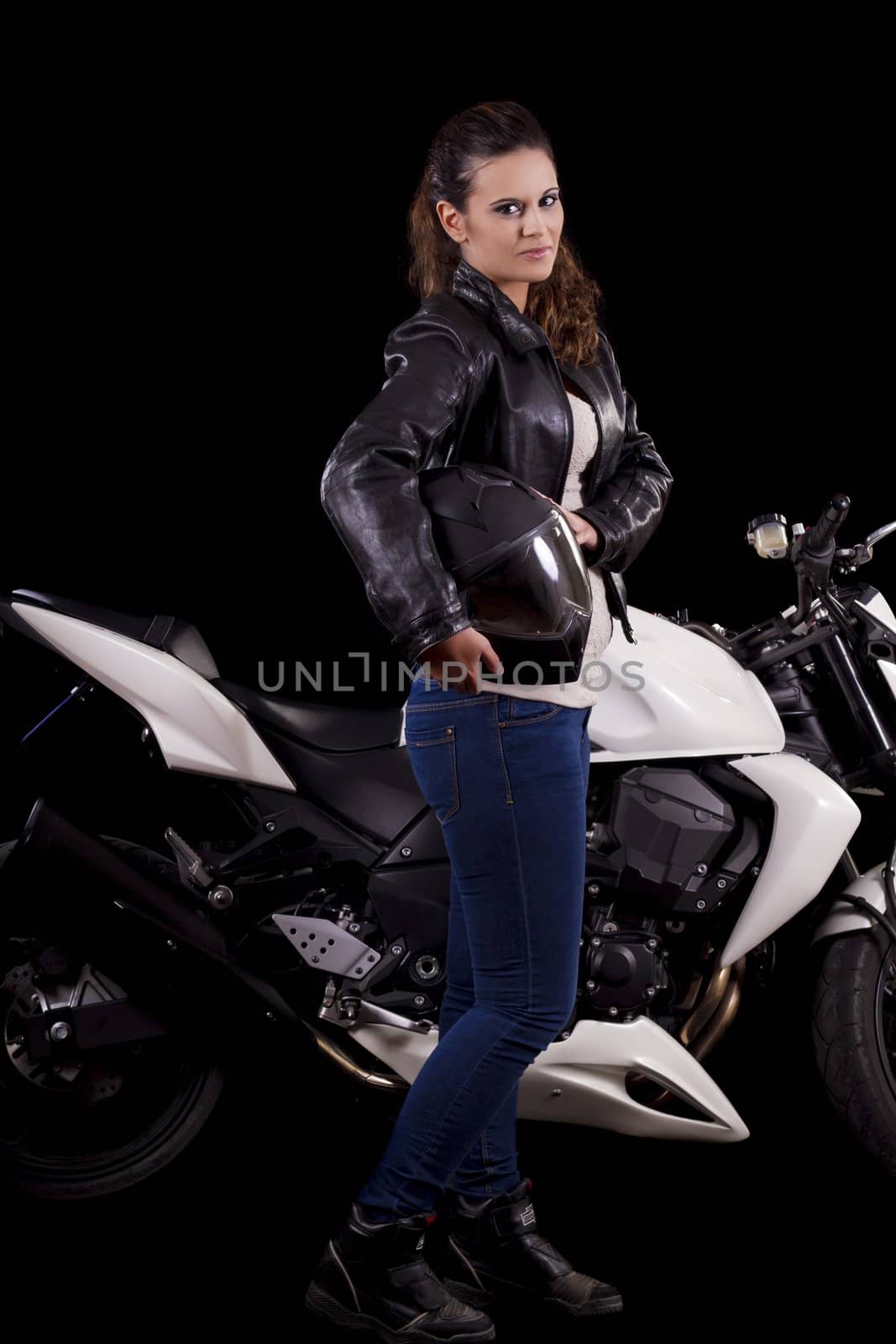 View of a beautiful young girl next to a white motorbike in a studio environment. 