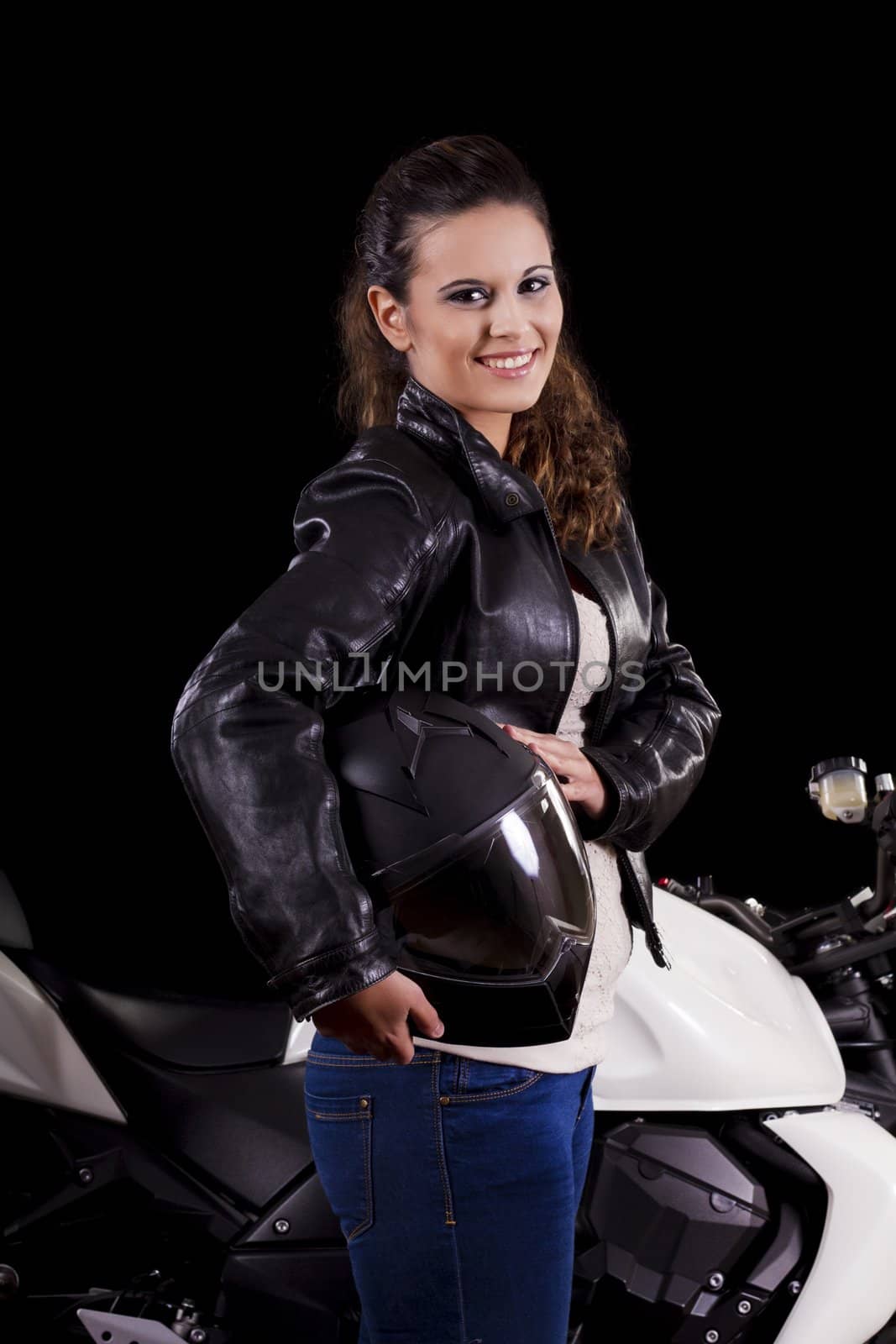 View of a beautiful young girl next to a white motorbike in a studio environment. 