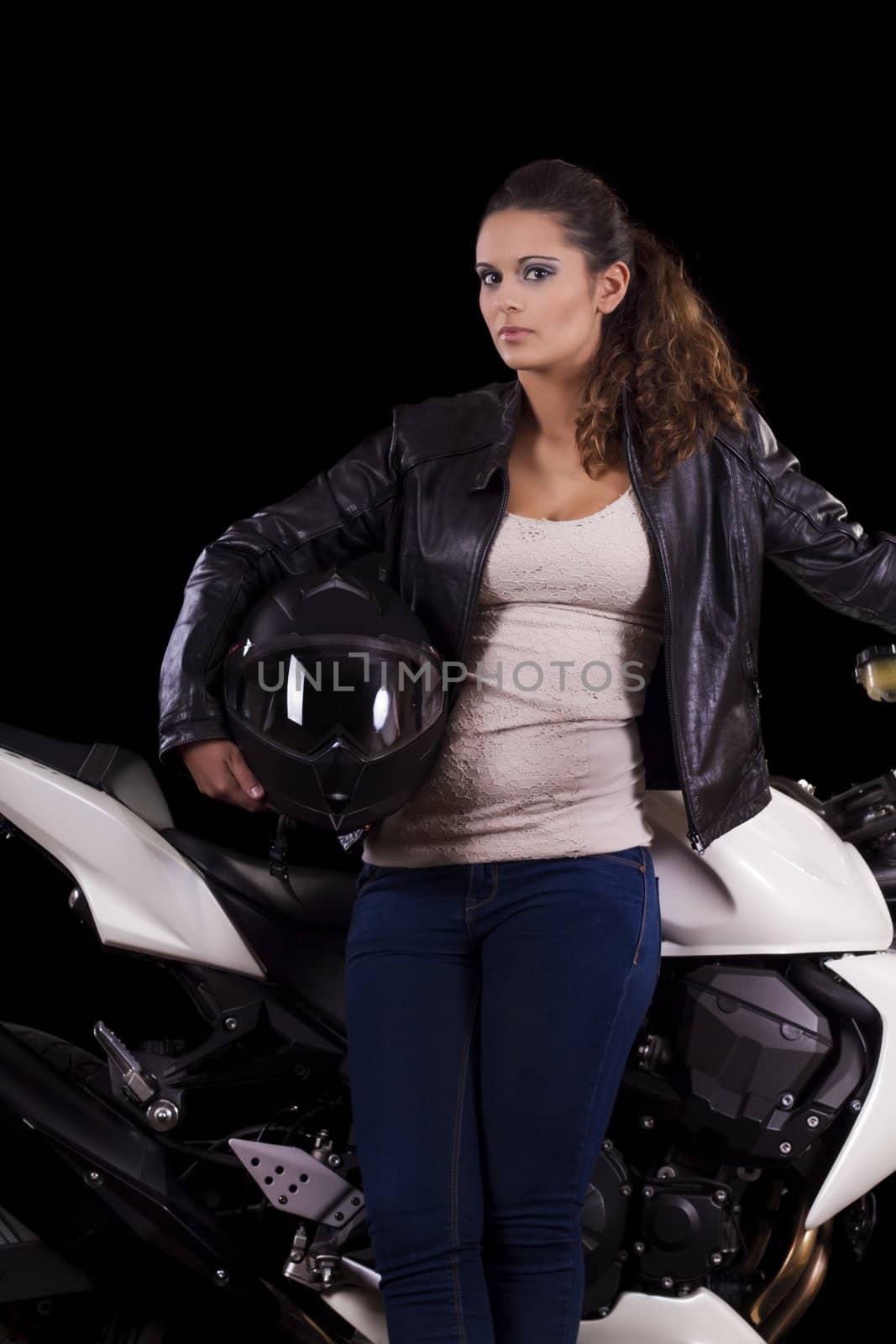 View of a beautiful young girl next to a white motorbike in a studio environment. 