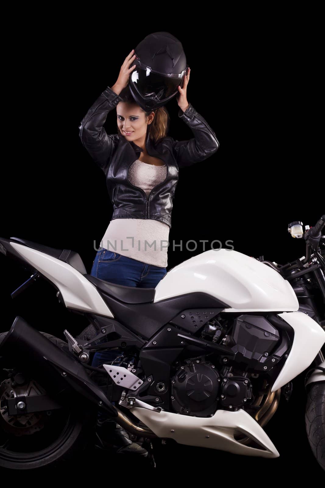 View of a beautiful young girl next to a white motorbike in a studio environment. 