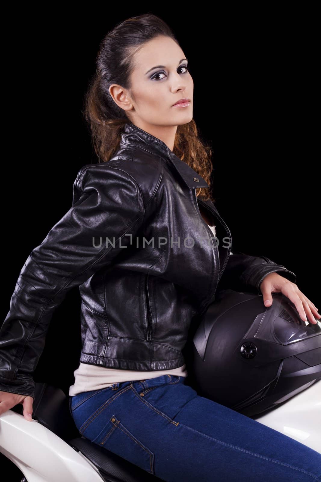 View of a beautiful young girl next to a white motorbike in a studio environment. 