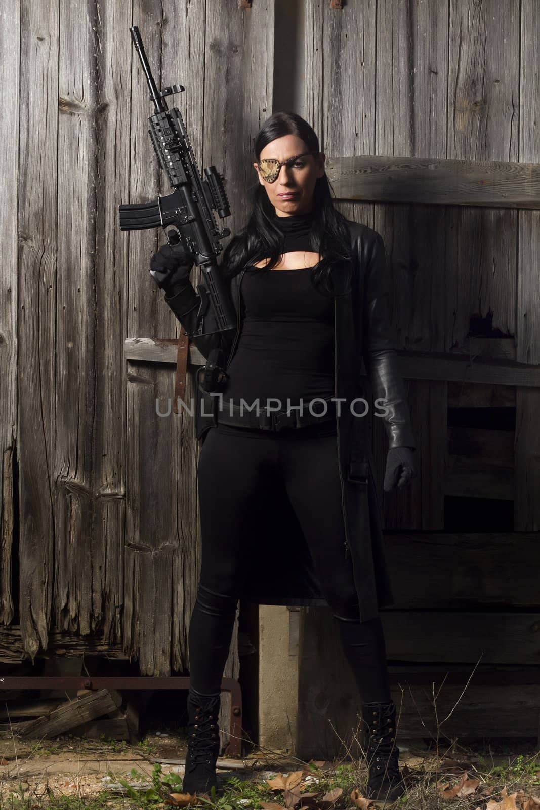 View of a beautiful action girl holding a weapon in a outdoor location.