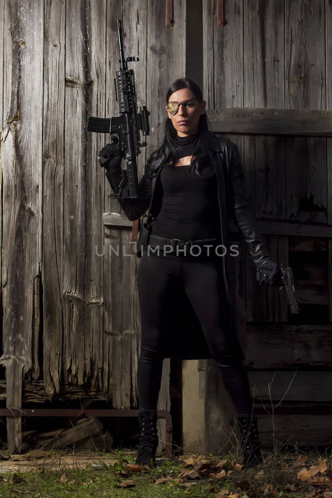 View of a beautiful action girl holding a weapon in a outdoor location.