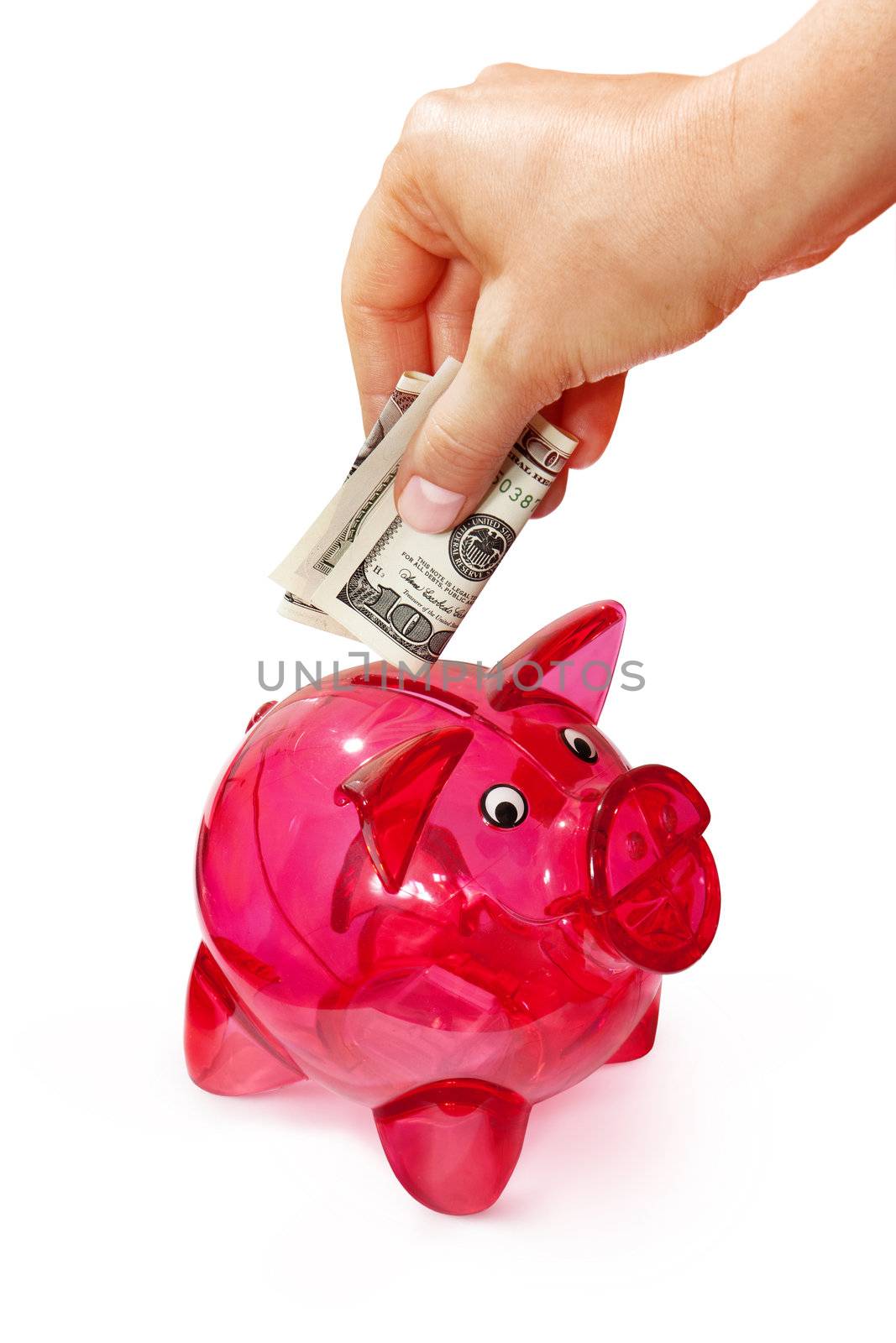 hand putting banknote into piggy bank by ssuaphoto