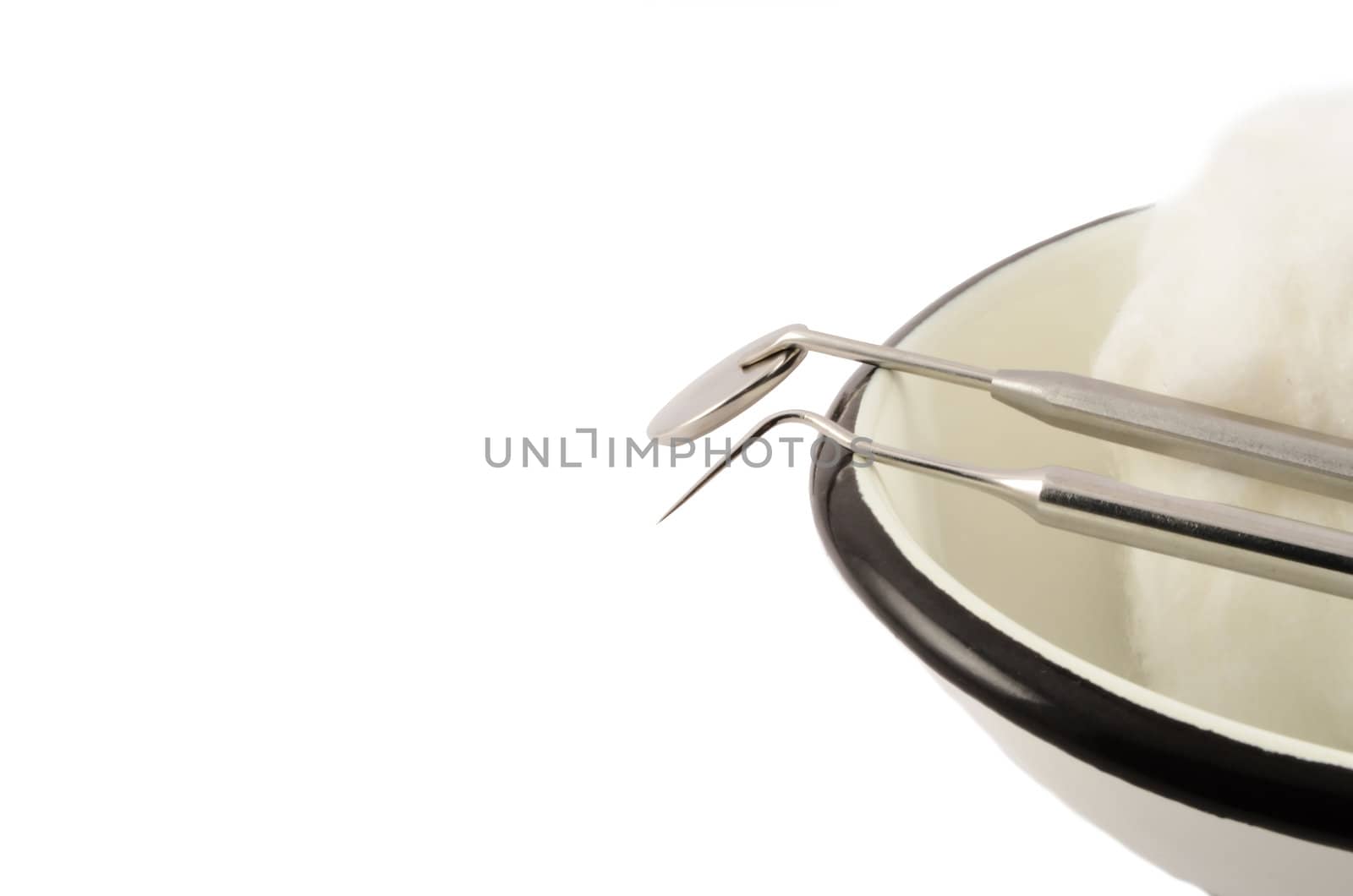 Medical dental instruments on a metal tray on a white background
