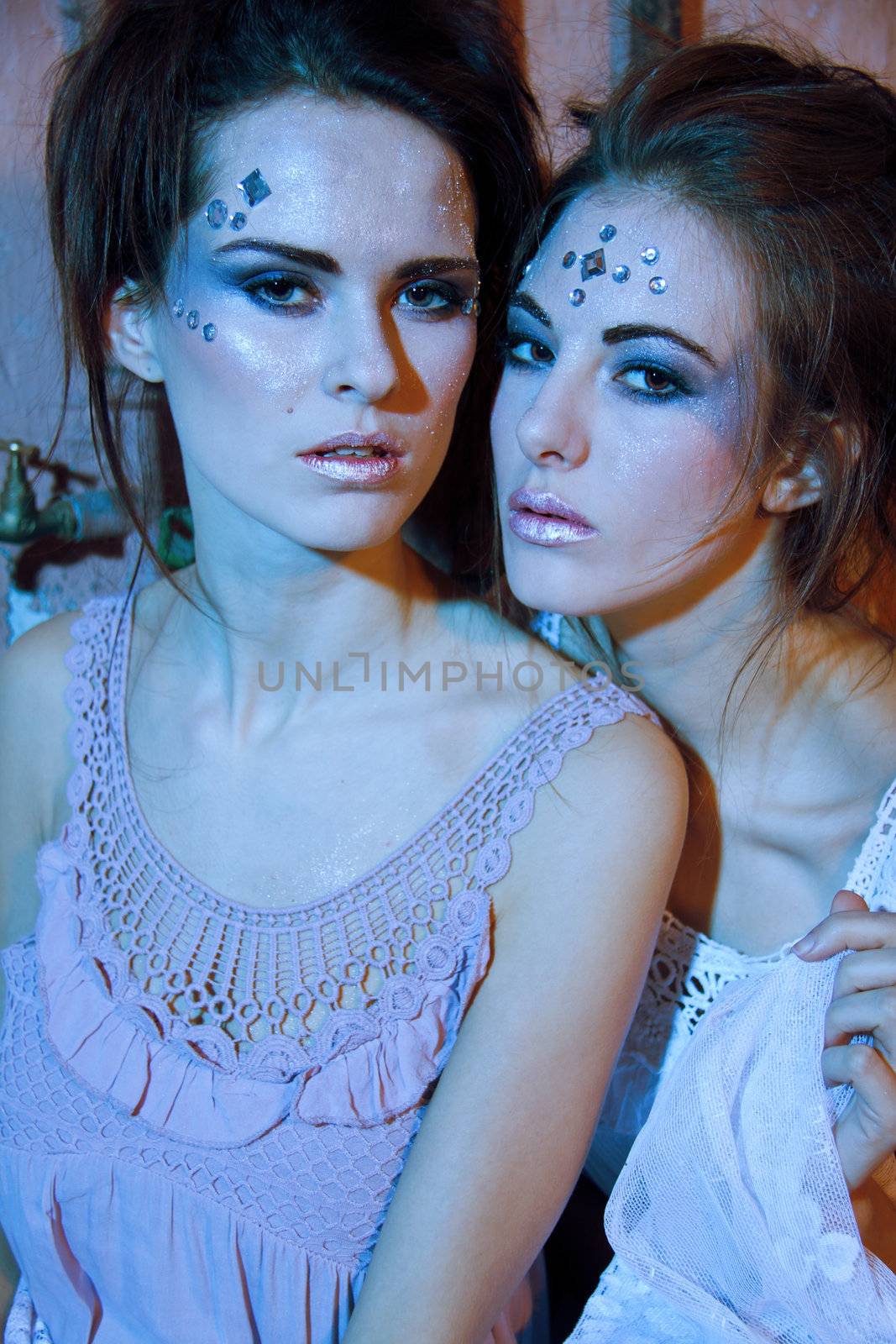 two beautiful girls in blue and glitter make up portrait