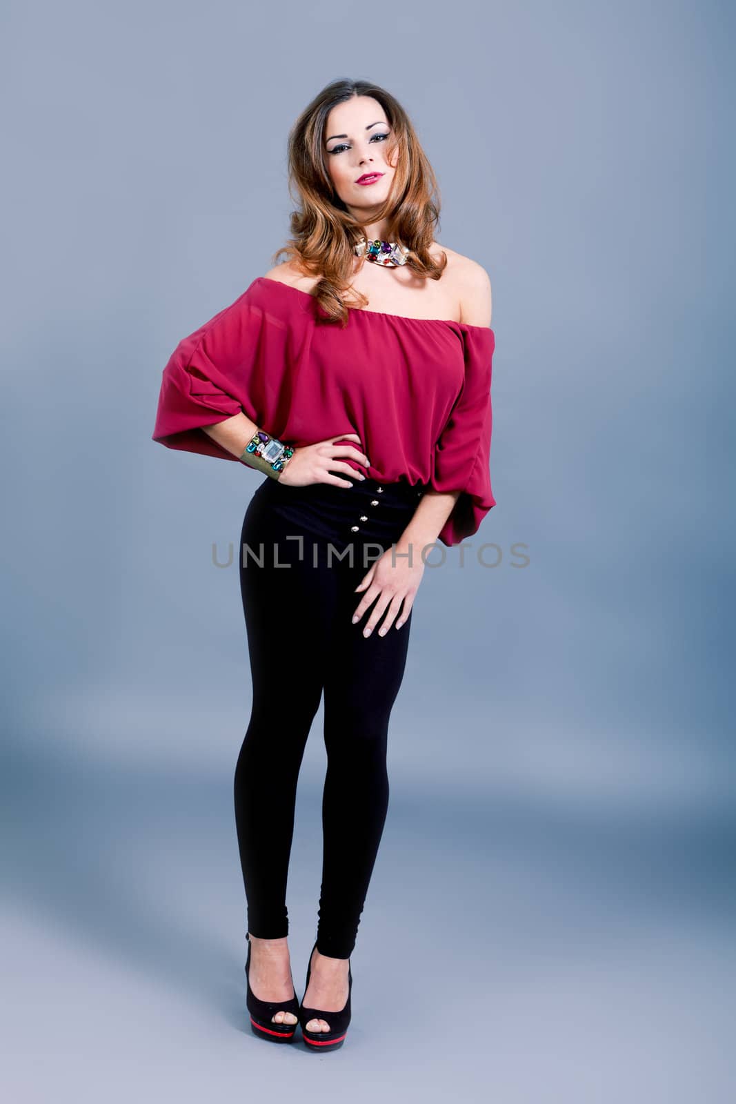 attractive brunette woman in elegant fashion on grey background
