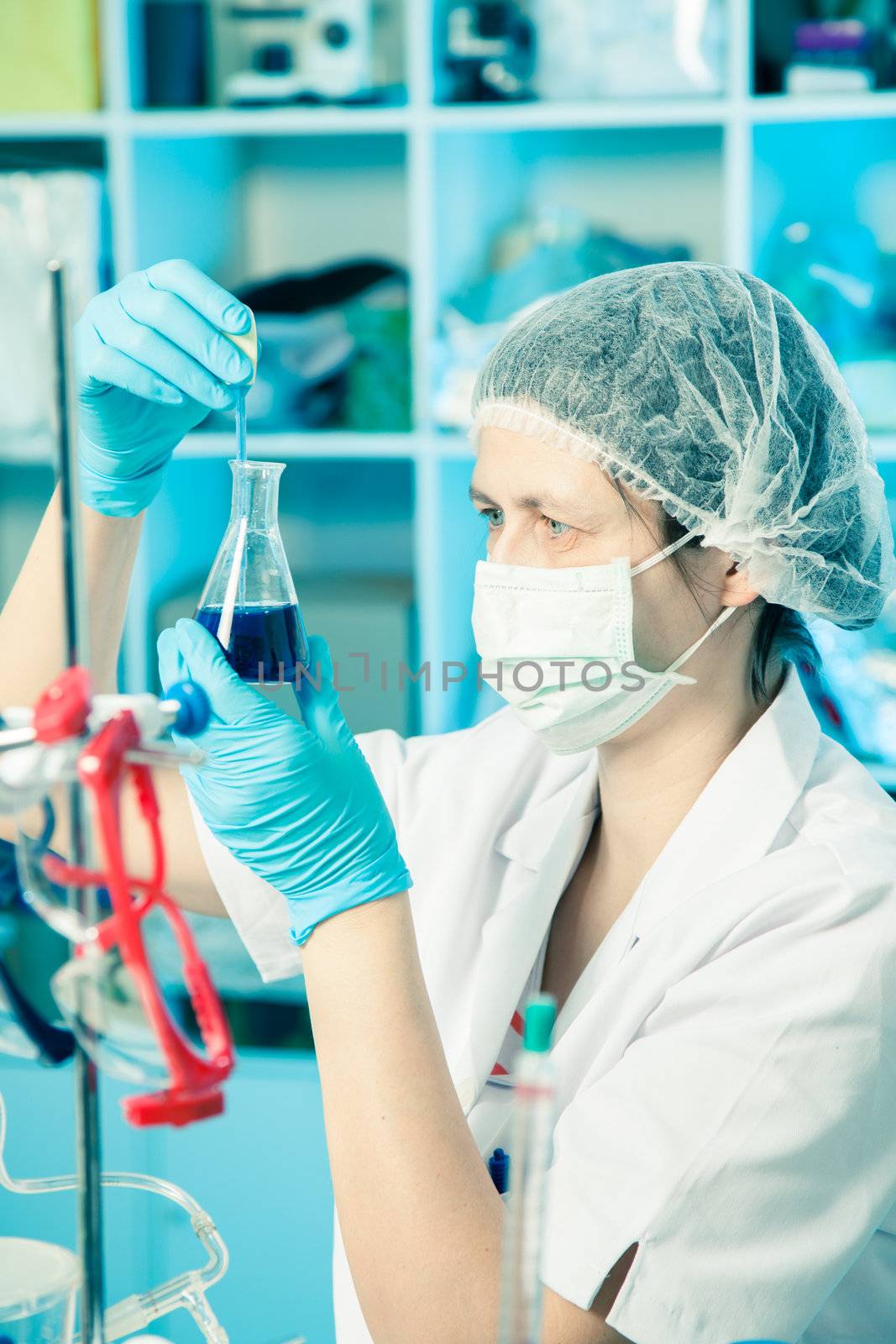 Scientific researcher holding at a liquid solution in a lab