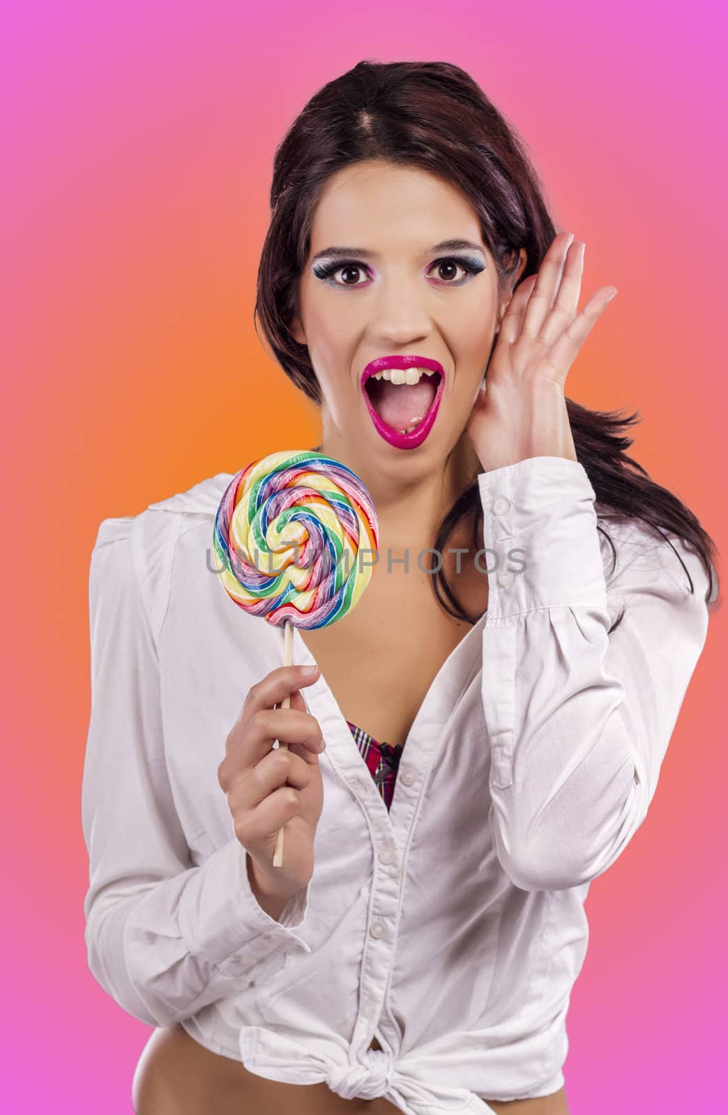 View of a beautiful girl with a colorful lollipop. 