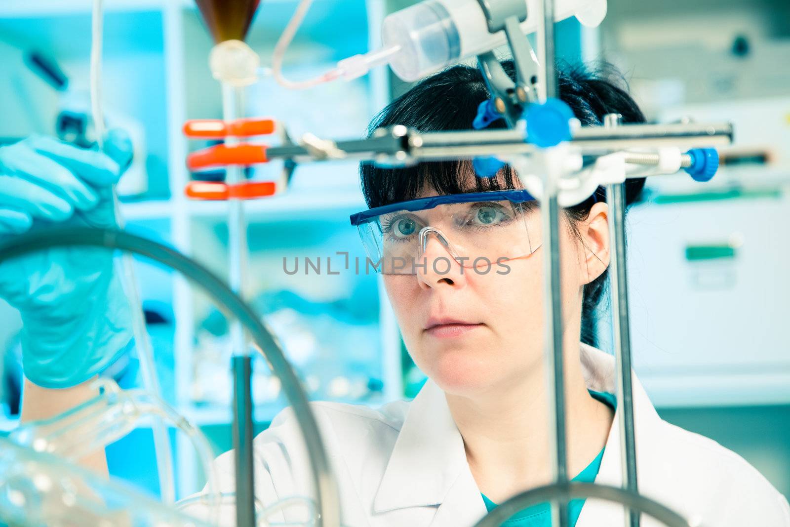 Scientific researcher holding at a liquid solution in a lab