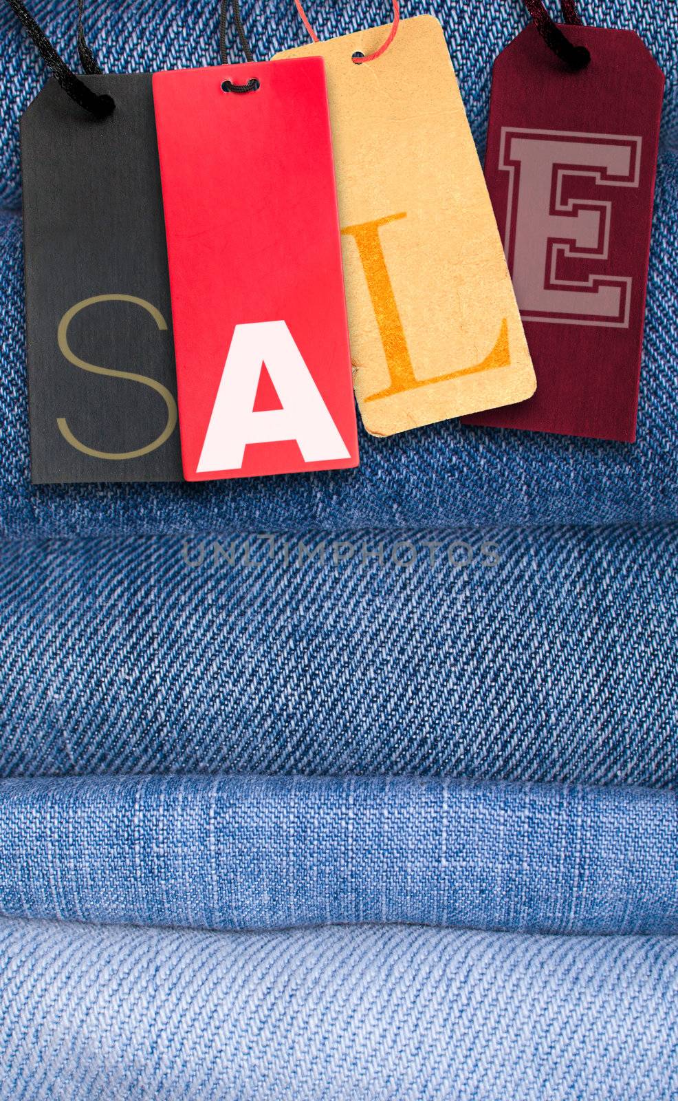 Paper Tags With Sale Sign on Stack of Blue Jeans