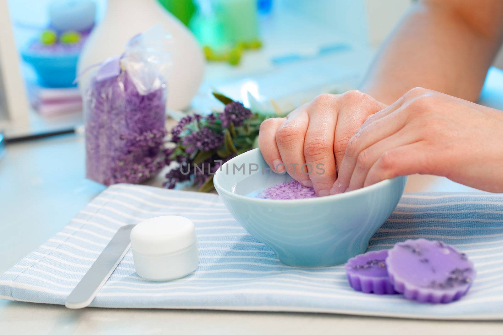 Client soaks her hands in a bowl of fragrant water before manicure