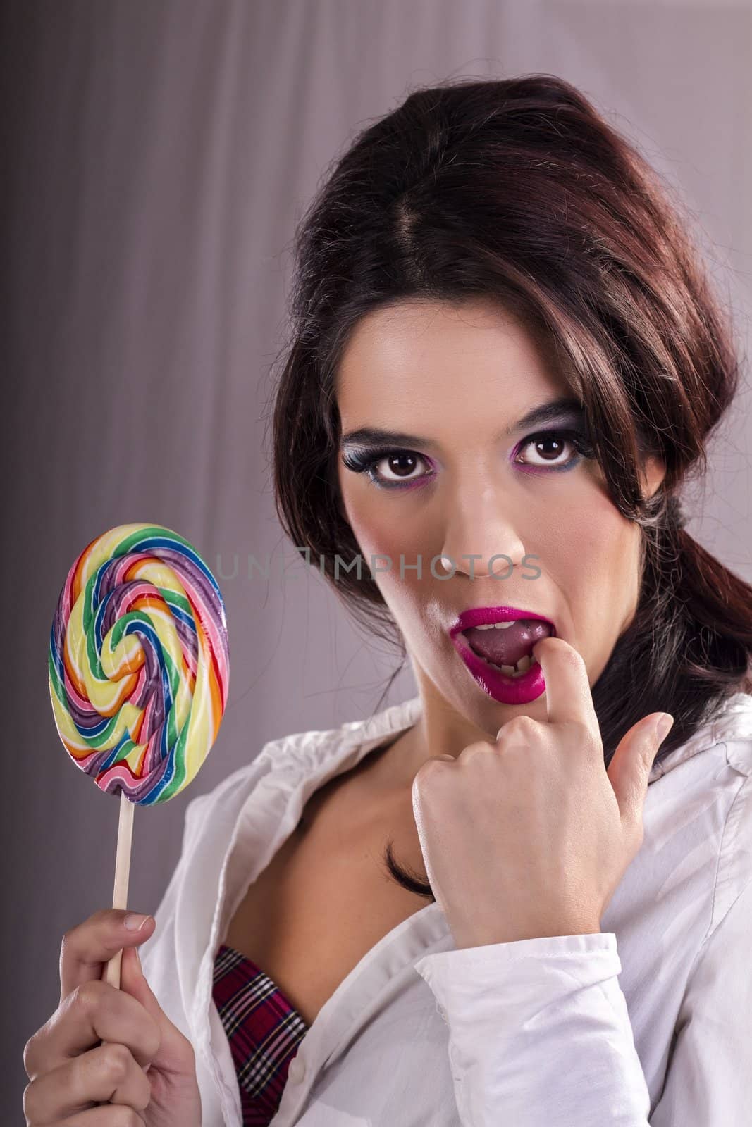 View of a beautiful girl with a colorful lollipop. 