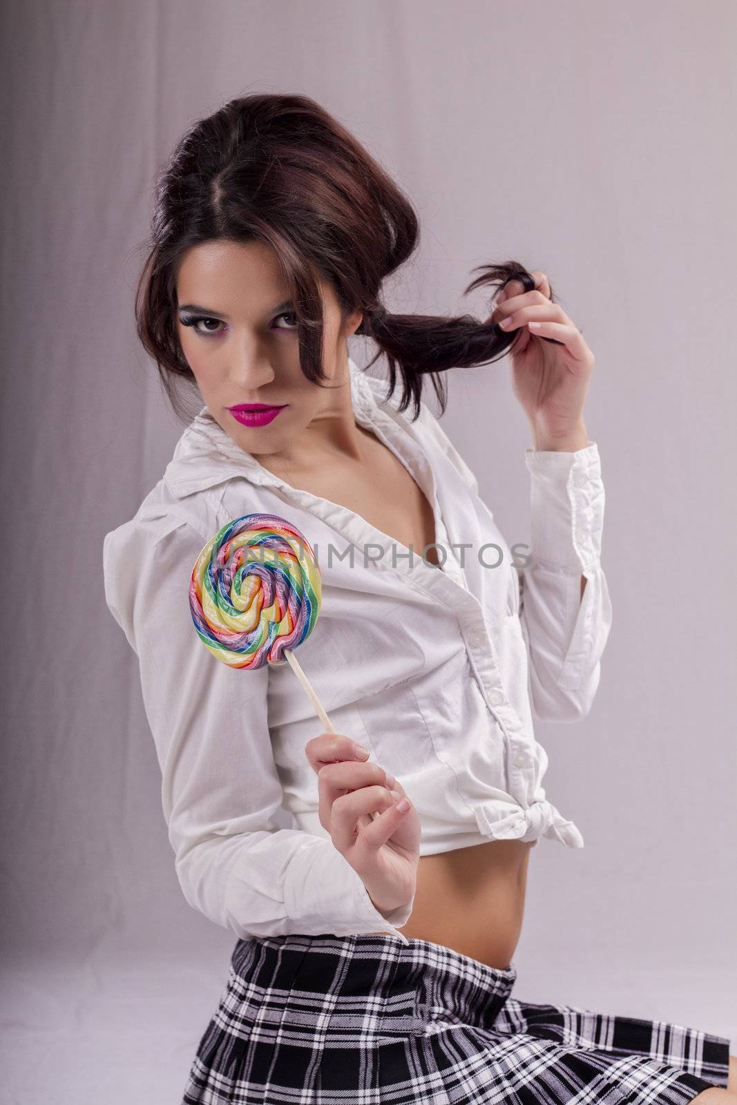 View of a beautiful girl with a colorful lollipop. 