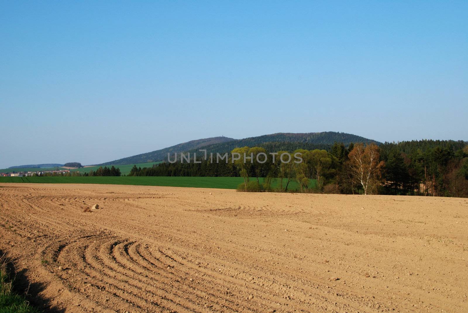 Freshly ploughed filed in the spring and a rural landscape