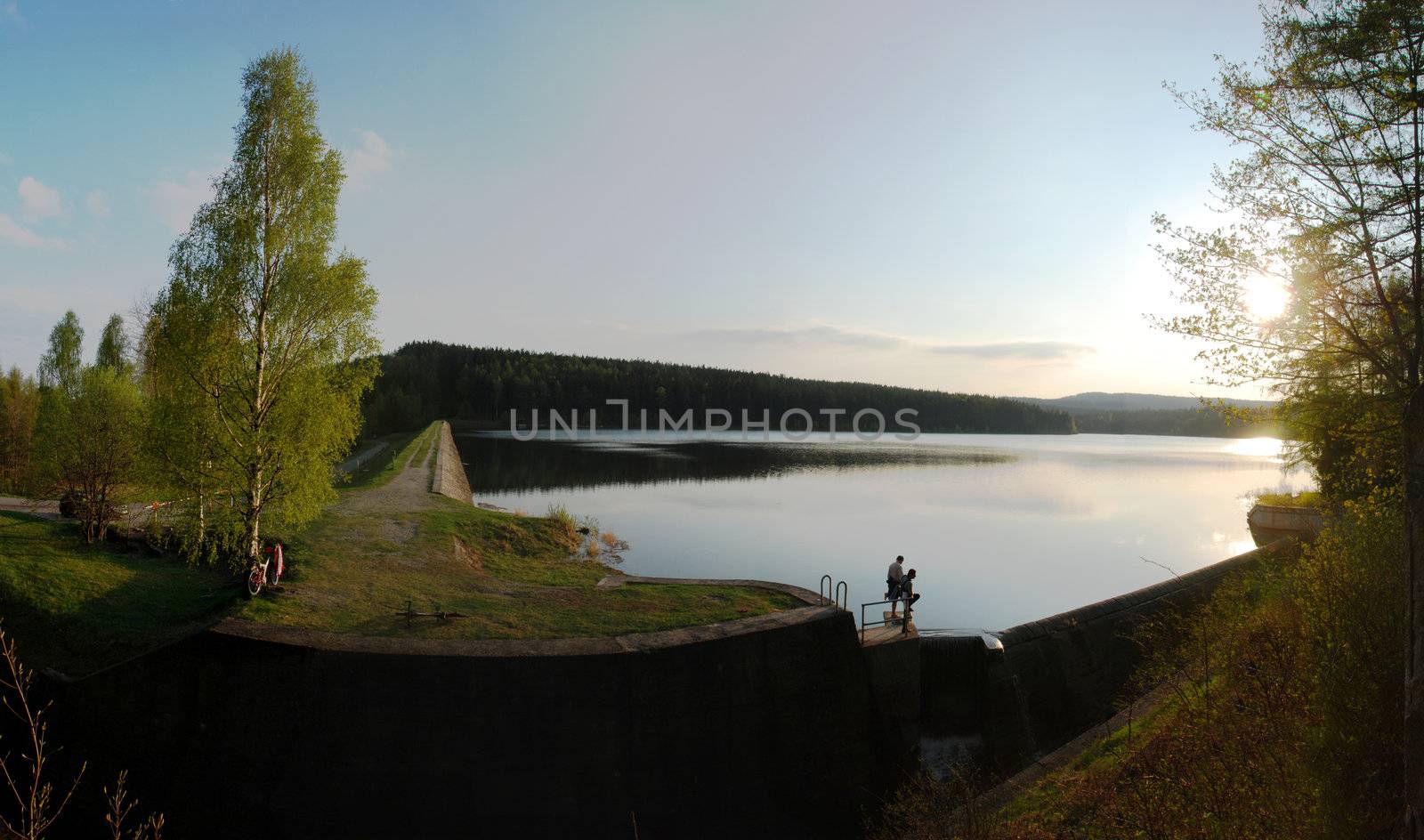 Sun is setting over the lake. Panoramic photo