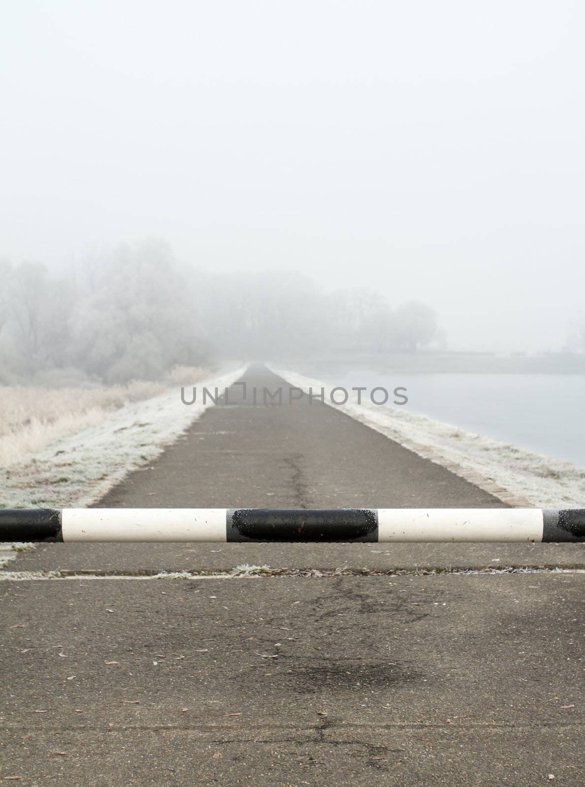 road to far away with barrier on freeze hoarfrosted landscape