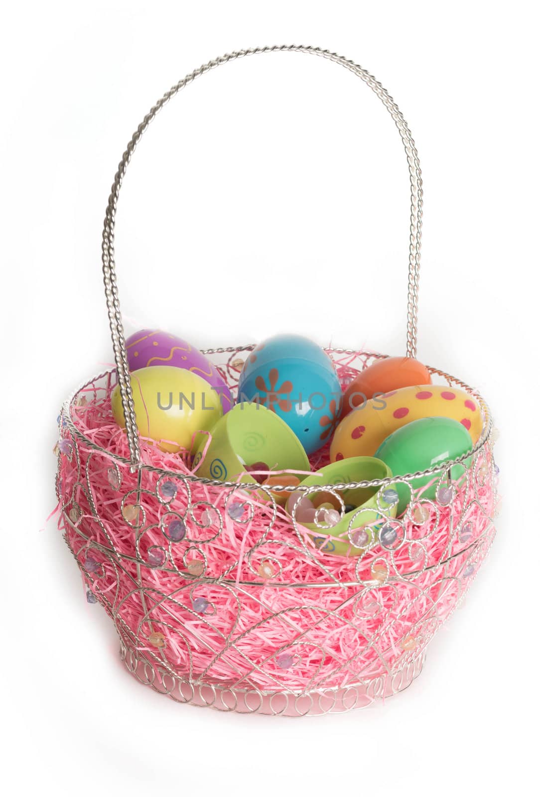 Decorated Easter eggs in Easter basket with pink decorative grass.  Isolated on white background.