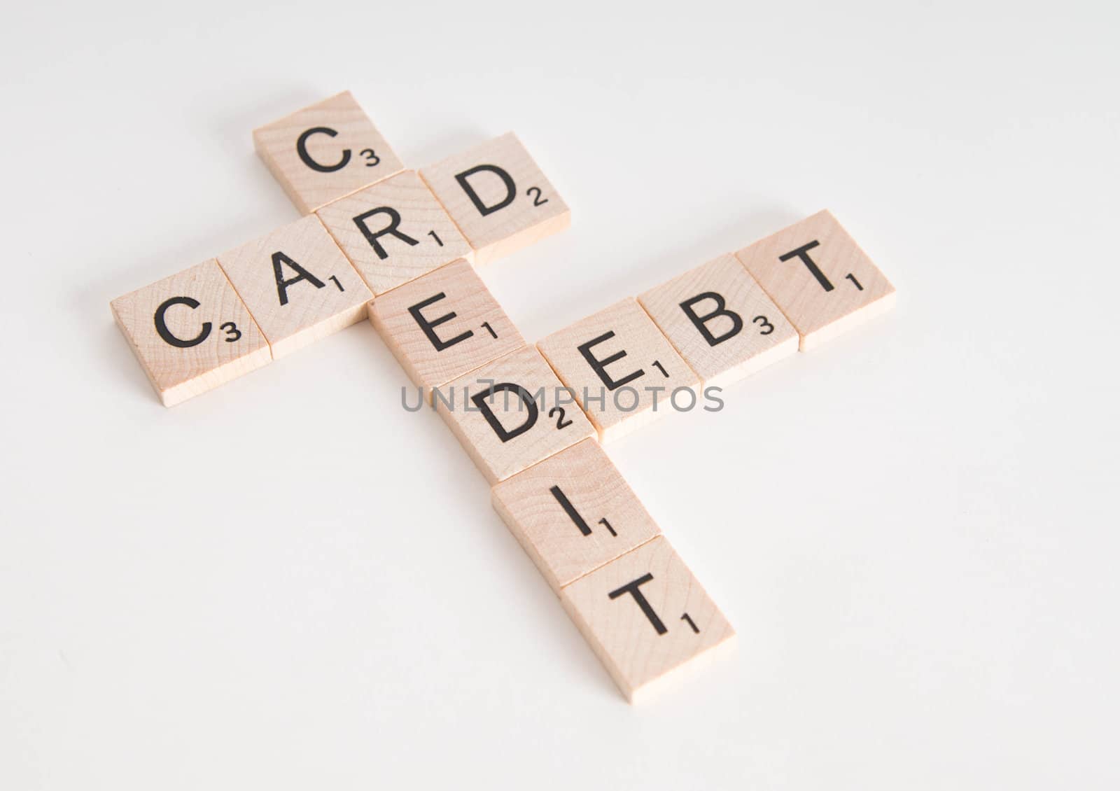 "Credit Card Debt" concept spelled in Scrabble letters. Isolated on white background.