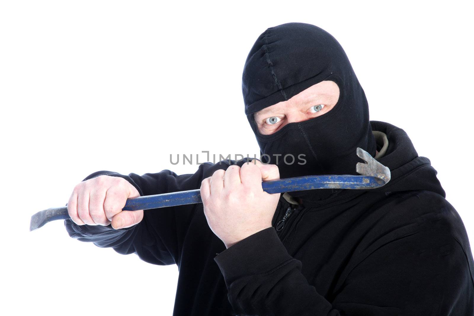 Masked male robber in a black balaclava wielding a crowbar in front of him in a threatening manner isolated on white
