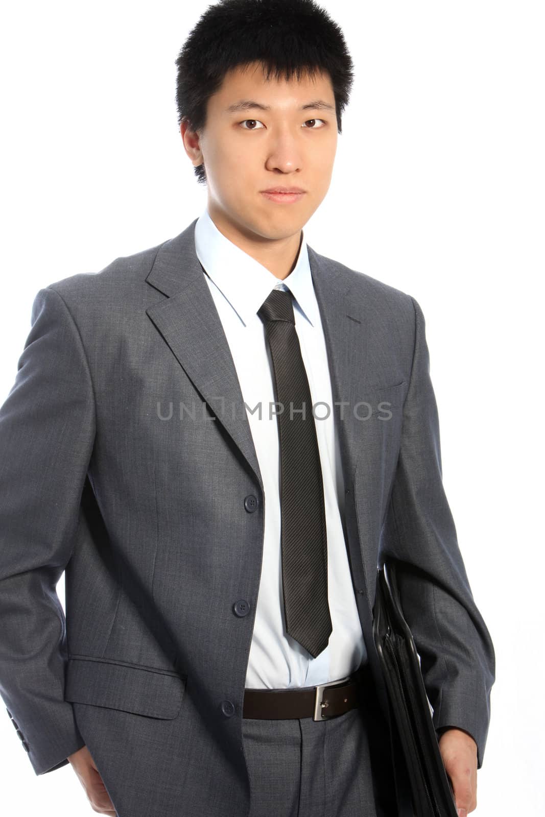 Serious asian businessman in gray suit posing on white background