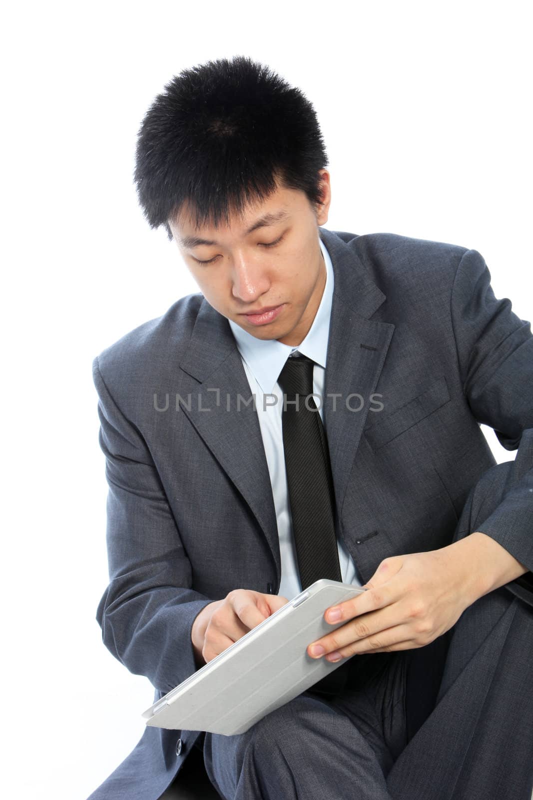Serious young businessman working on his tablet isolated on white