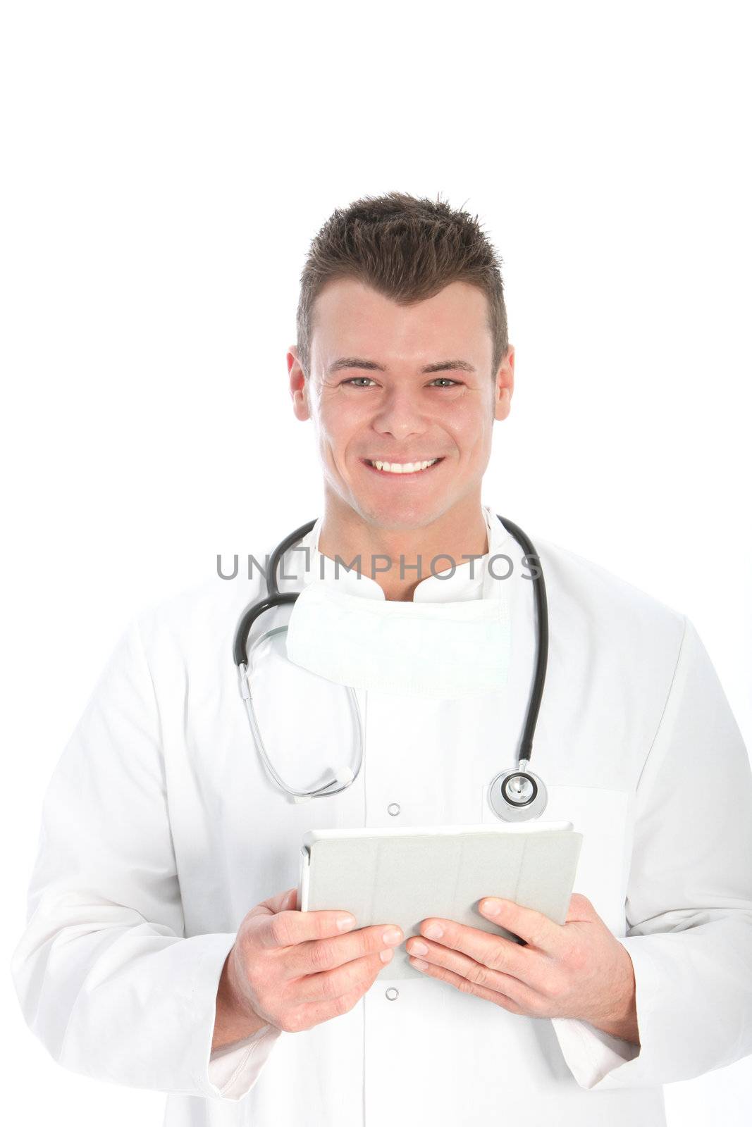 Smiling confident young male doctor working with a tablet in his hands as he checks patient records and consults the latest medical research journals and information isolated on white