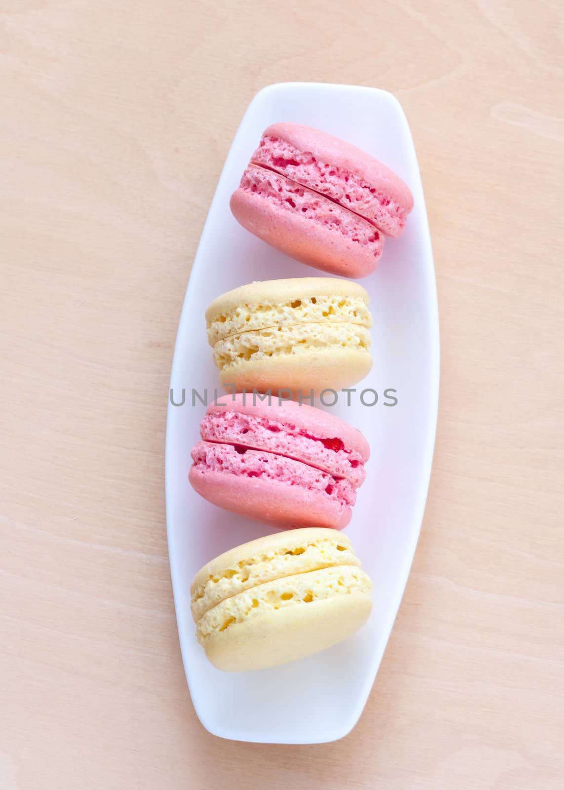 pink and yellow macaron on a plate by sfinks