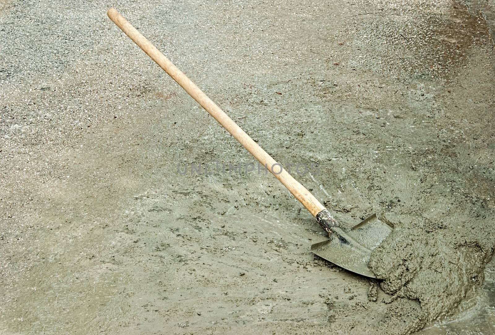 Shovel and wet cement mixture on the road