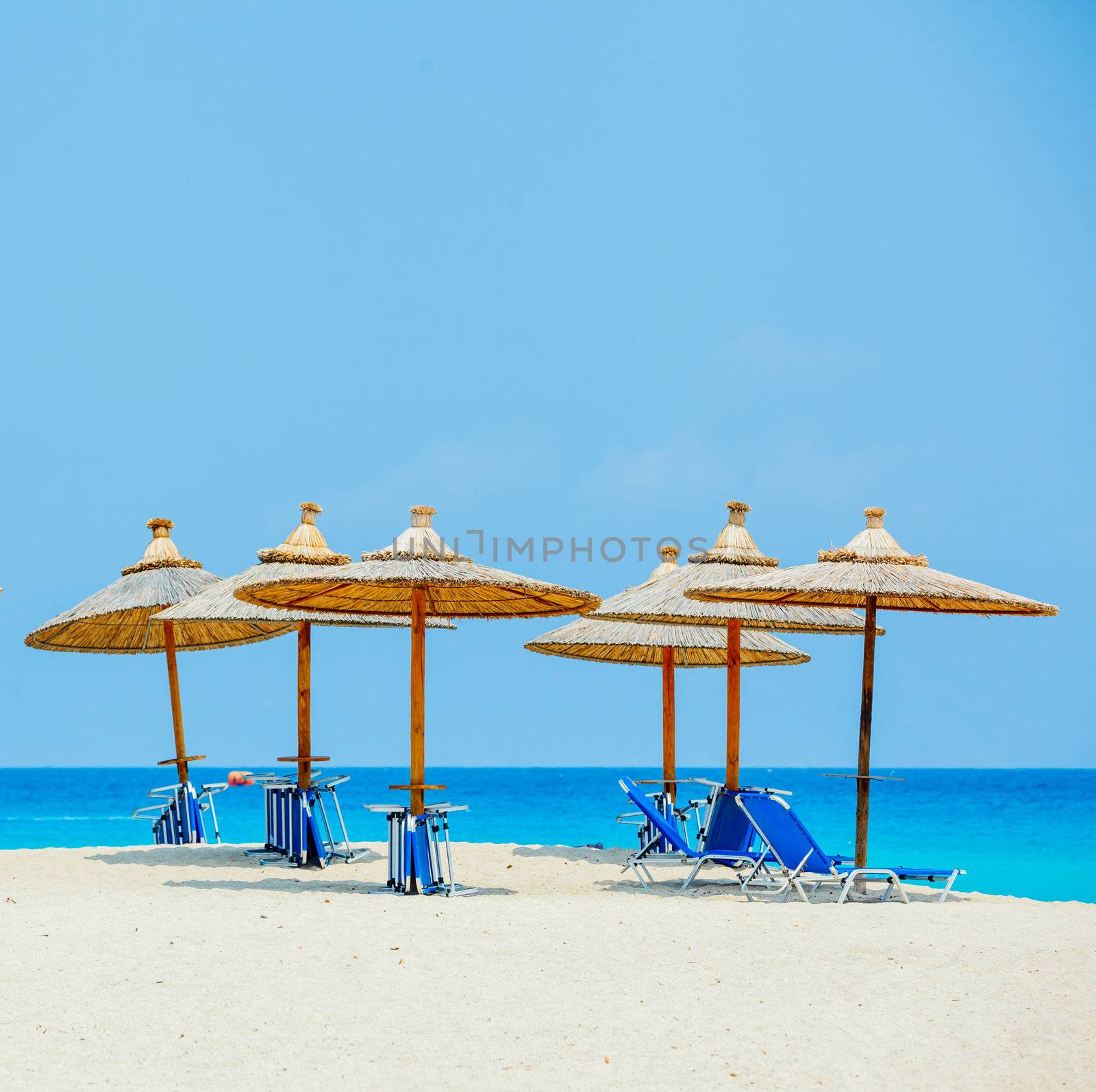 Beach chairs with umbrella and beautiful beach on a sunny day